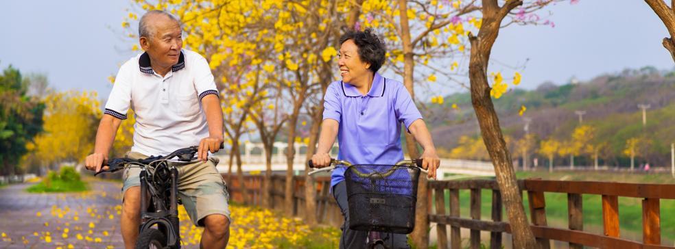 Image of a male and a female riding bikes along a road
